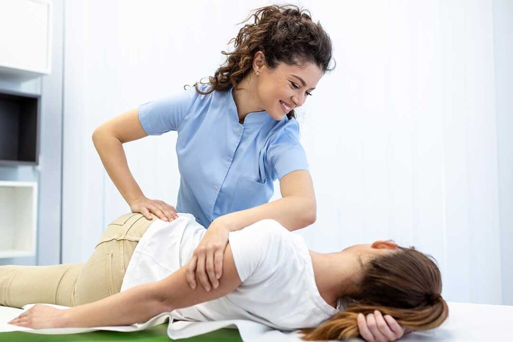 Clinician uses a smooth handheld instrument on a patient’s calf during a soft tissue treatment session.